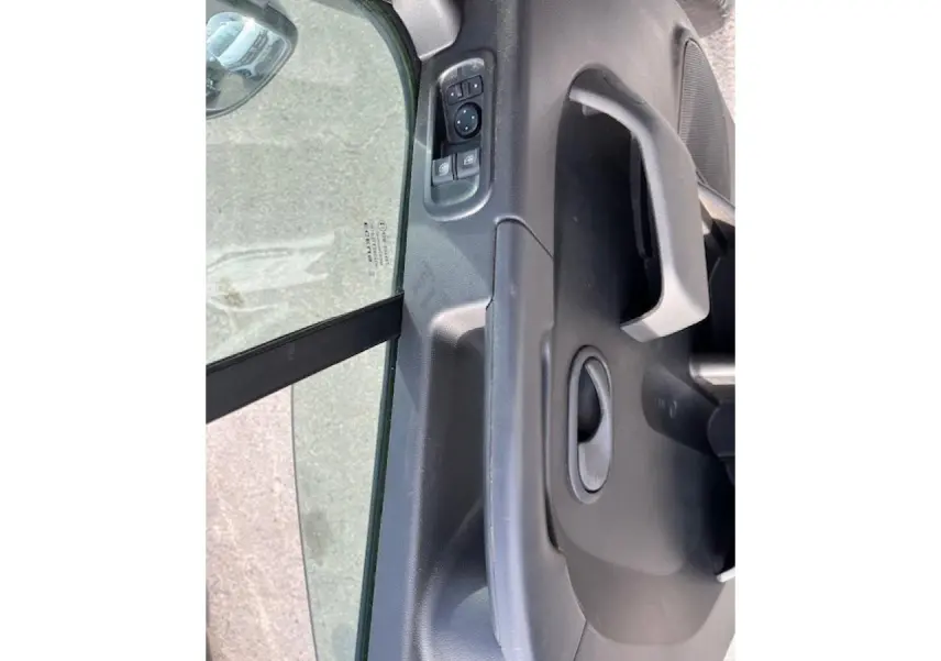 Détail de la porte côté conducteur du Renault Master blanc 2024, avec commandes électriques des vitres et poignée intégrée.