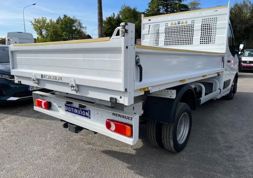 Vue 3/4 arrière droite d’un Renault Master blanc 2024 avec benne basculante et plaque d’immatriculation Distinxion.