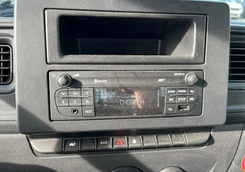 Vue rapprochée de la radio et des commandes centrales du tableau de bord du Renault Master blanc 2024, version benne basculante.