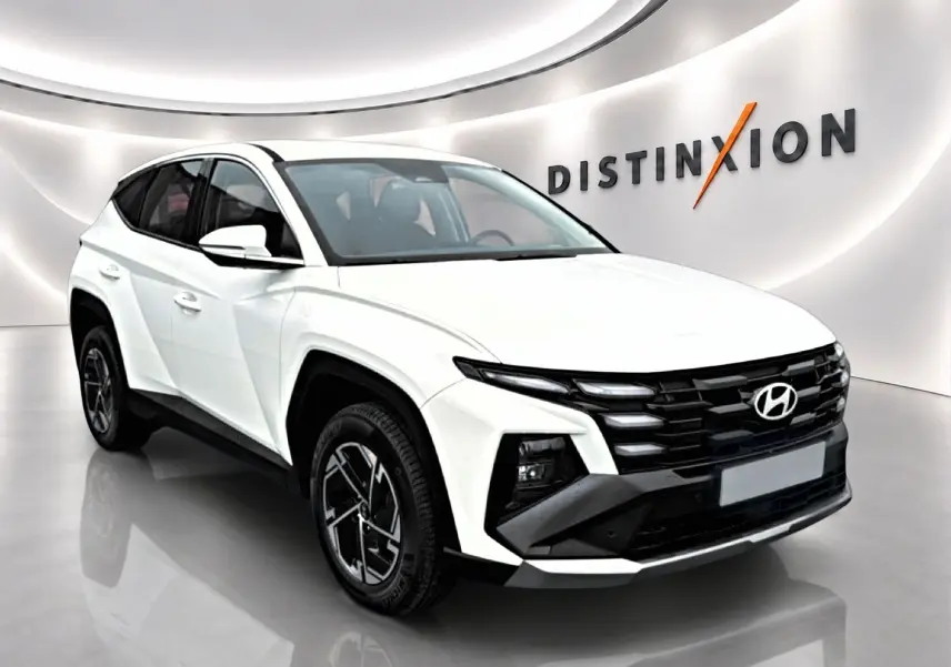Hyundai Tucson blanc 2026 en 3/4 avant droit, avec calandre noire et jantes alliage 17 pouces distinctives.