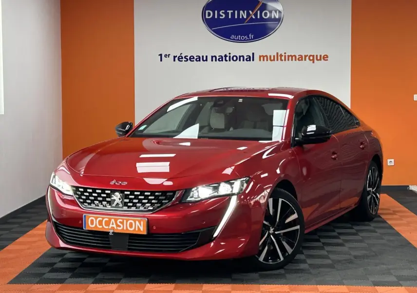Peugeot 508 Hybrid rouge clair vue 3/4 avant droit avec jantes alliage bi-ton et éclairage LED distinctif.