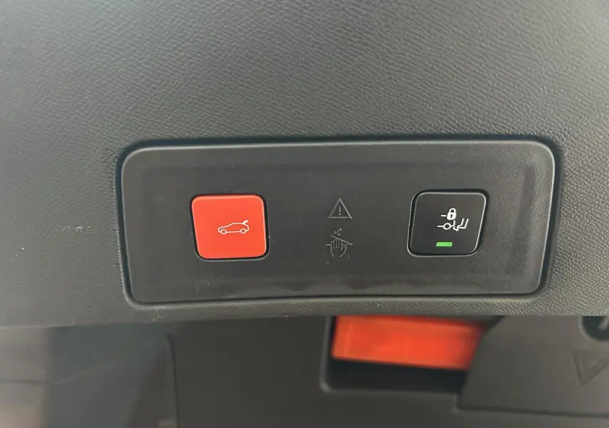 Boutons de commande du hayon électrique et verrouillage enfant sur la garniture intérieure d'une Peugeot 508 rouge clair.