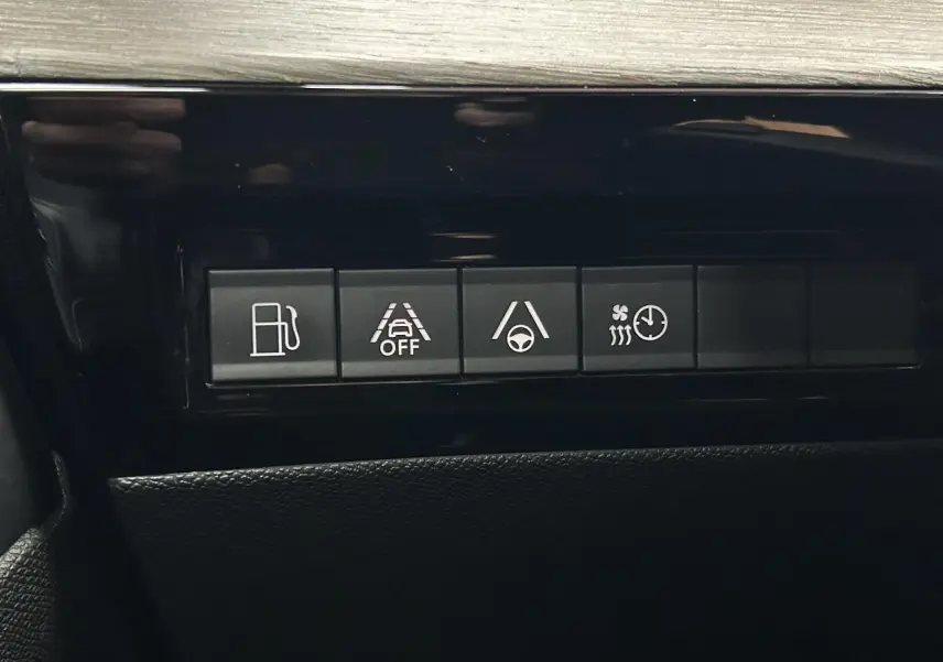 Boutons de commande du tableau de bord de la Peugeot 508 Hybrid rouge clair, avec aides à la conduite et chauffage.
