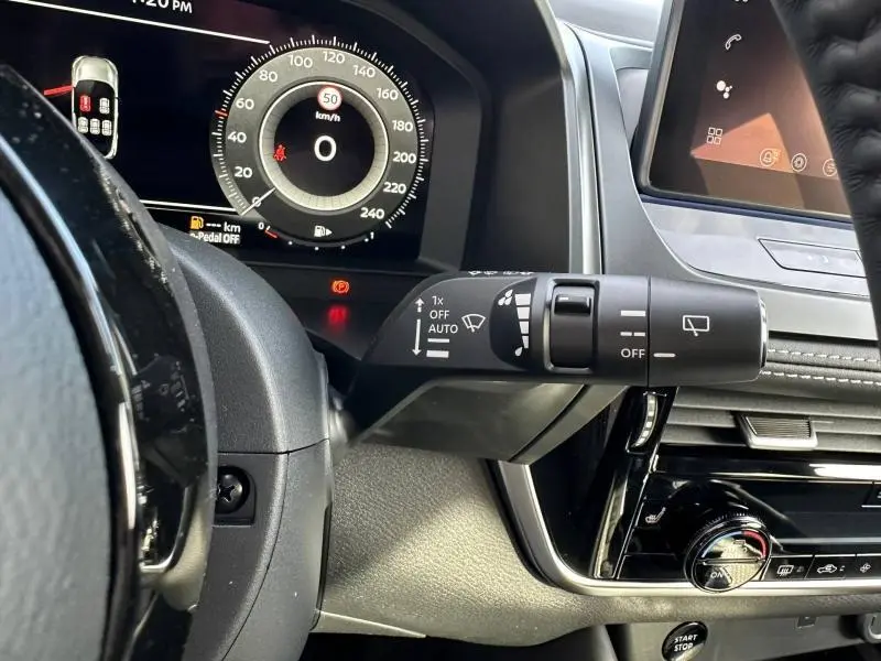 Vue intérieure du tableau de bord du Nissan Qashqai Hybrid e-POWER 2025, mettant en valeur le combiné numérique et la commande d’essuie-glace.