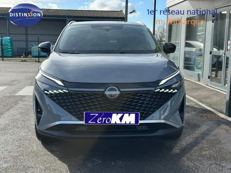 Vue frontale d'un Nissan Qashqai Hybrid e-POWER 205ch N-Connecta gris Argile avec calandre noire texturée et phares LED distinctifs.