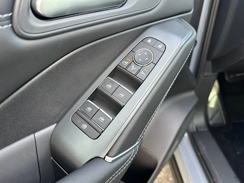 Gros plan sur les commandes de lève-vitres et rétroviseurs côté gauche du Nissan Qashqai Hybrid e-POWER 2025 en Gris Argile.