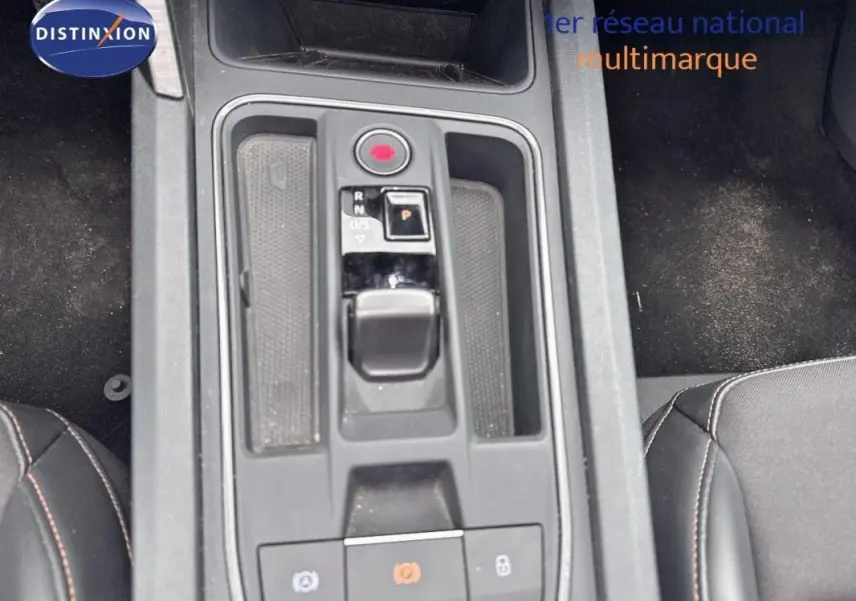 Vue plongeante sur la console centrale grise de la CUPRA Leon ST 2024 avec levier de boîte automatique et frein à main électronique.