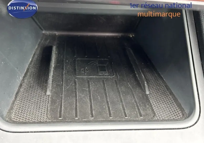 Gros plan sur le chargeur sans fil noir intégré à la console centrale de la CUPRA Leon ST gris 2024.