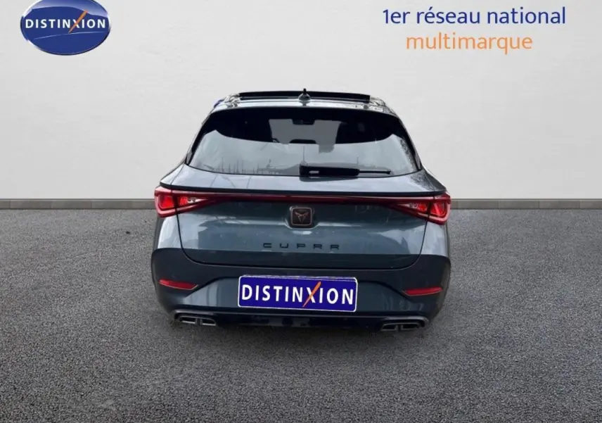 Vue arrière d'une CUPRA Leon ST gris 2024 avec feux reliés et double sortie d'échappement intégrée.