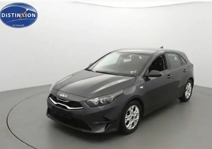 KIA CEE'D gris vue 3/4 avant droit dans studio, avec jantes 16 pouces et calandre moderne.
