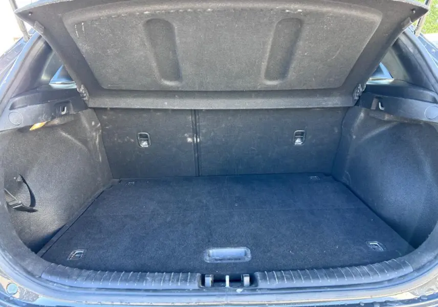 Coffre ouvert vu de l'arrière d'une KIA CEE'D gris 2022, montrant un espace de chargement propre et vide.