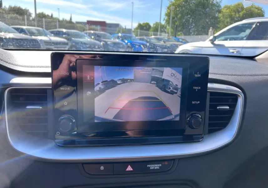 Écran central de Kia CEE'D 2022 montrant la caméra de recul avec vue arrière en plein jour.