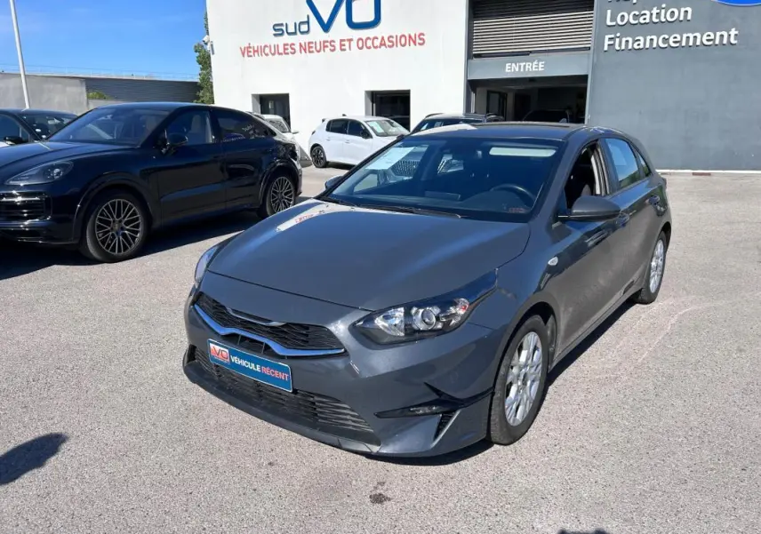 KIA CEE'D gris vue 3/4 avant droit, avec jantes 16 pouces et calandre noire brillante.