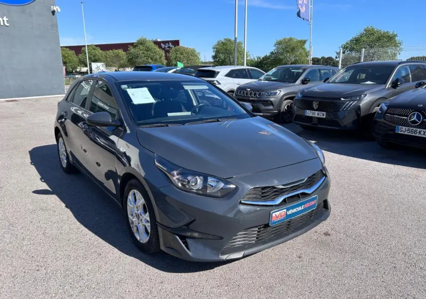 KIA CEE'D gris vue 3/4 avant droit, avec jantes 16 pouces et calandre noire brillante.