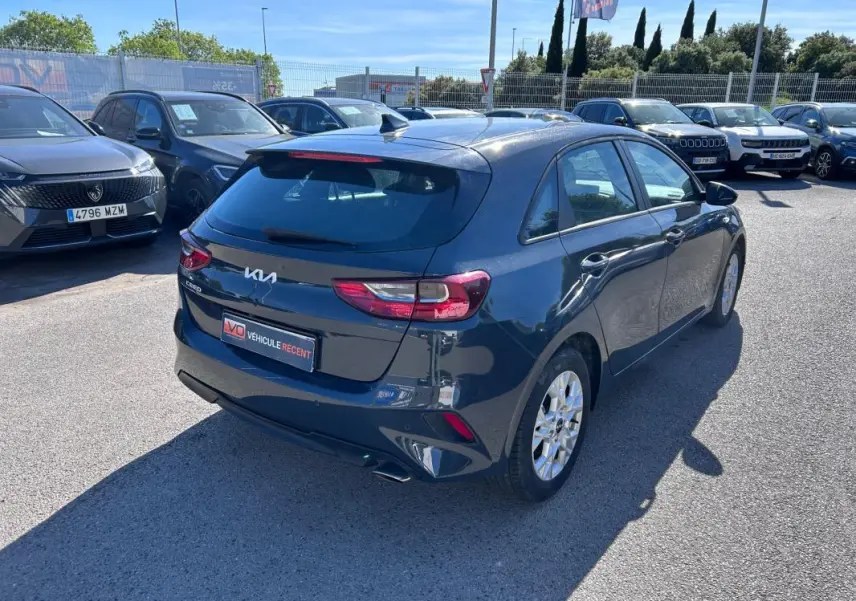 Vue 3/4 arrière droite d'une KIA CEE'D gris métallisé avec jantes 16 pouces, stationnée en extérieur au soleil.