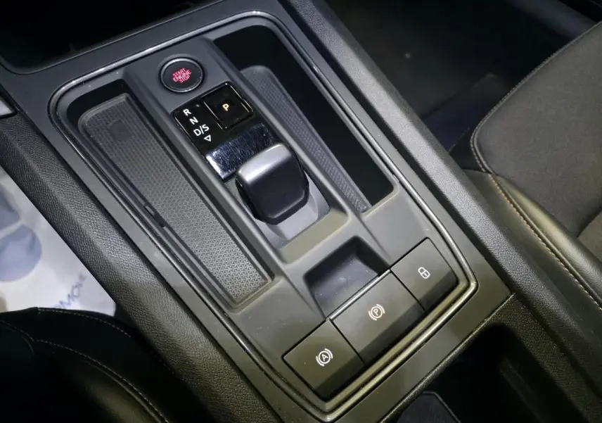 Vue rapprochée de la console centrale noire avec levier de vitesse automatique et boutons de commande du CUPRA Leon 2023.