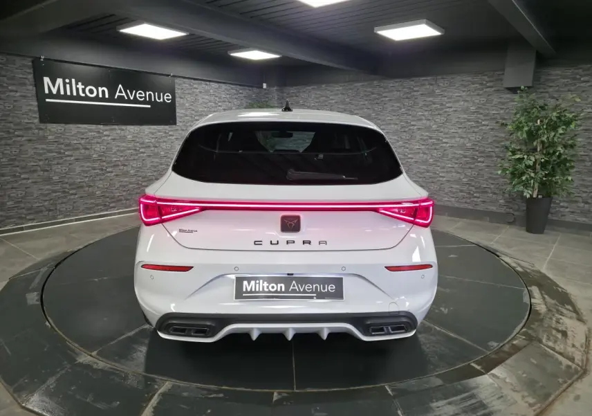 Vue arrière d'une CUPRA Leon blanche Nevada 2023 avec feux LED bandeau Infinite Light et double sortie d'échappement.