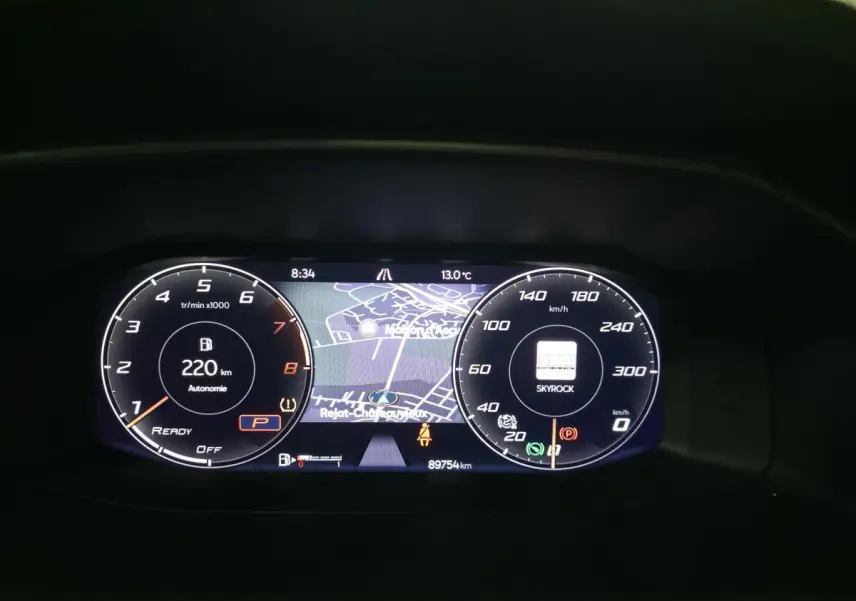 Combiné d'instruments digital de la CUPRA Leon 2023 affichant la navigation et l'autonomie essence hybride à 220 km.