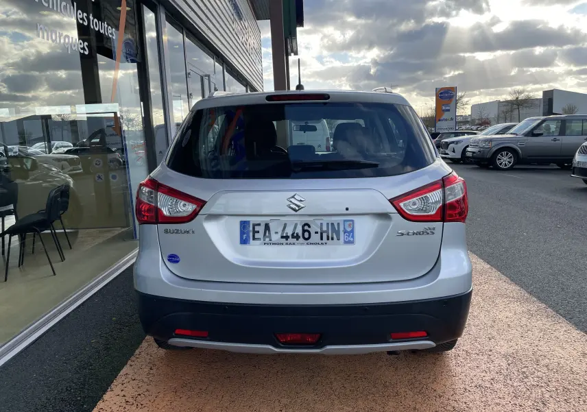 Vue arrière d'un Suzuki SX4 S-Cross gris métallisé 2016, avec feux arrière distinctifs et plaque d'immatriculation française.