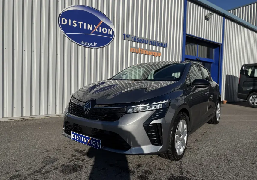 Renault Clio V gris schiste vue 3/4 avant droit, avec calandre noire et feux LED Pure Vision visibles.