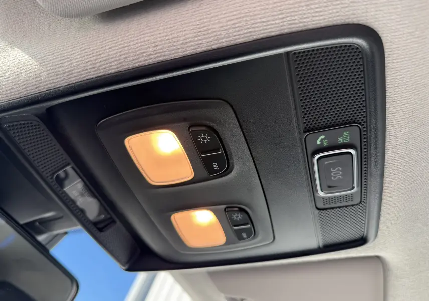 Plafonnier intérieur avec éclairage et bouton SOS activé sur Renault Clio V gris schiste, vue en contre-plongée vers l'avant.