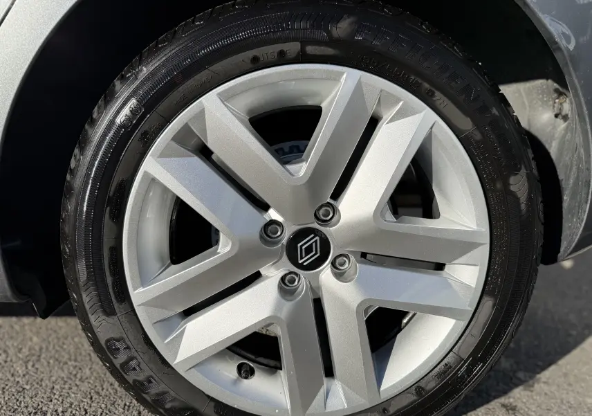 Gros plan sur la roue avant droite d'une Renault Clio V gris schiste, mettant en valeur la jante et le pneu.