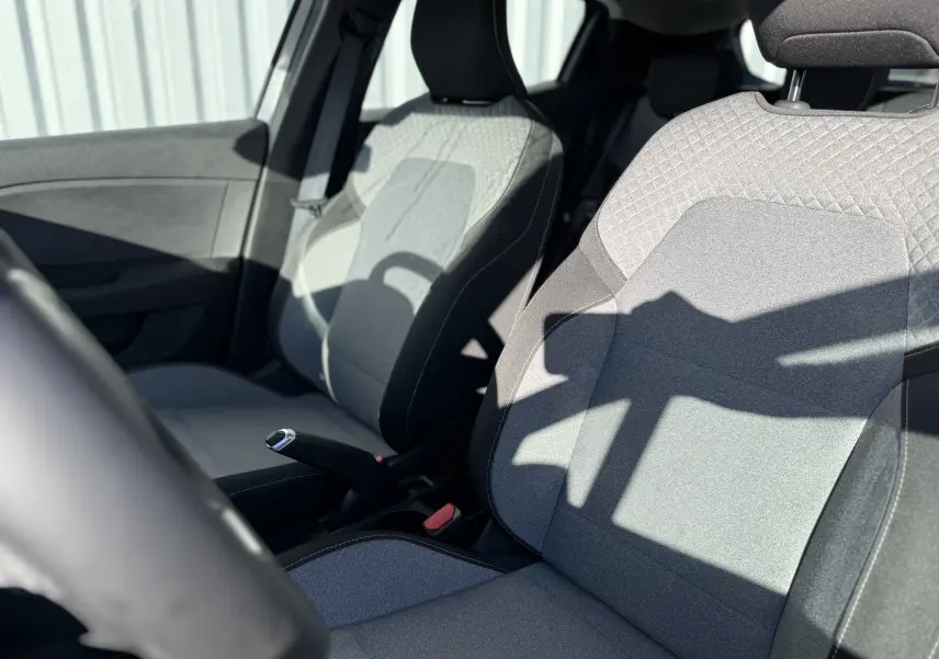 Gros plan sur les sièges avant gris clair et foncé de la Renault Clio V 1.5 dCi 100, vue côté conducteur.