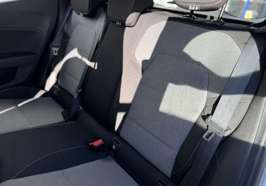 Vue rapprochée de la banquette arrière grise et noire de la Renault Clio V 1.5 dCi 2025 avec ceintures et appuie-têtes.
