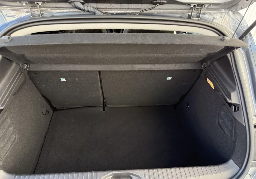 Coffre ouvert vu de dessus de la Renault Clio V gris schiste, montrant un espace de chargement vide et propre.