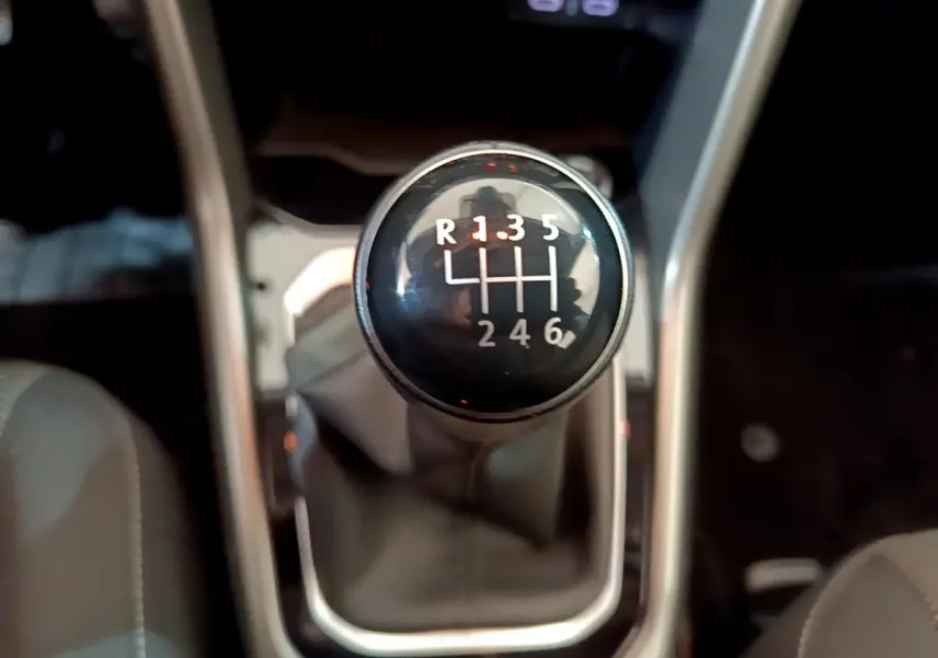 Gros plan sur le levier de vitesses manuel noir du Volkswagen T-Roc gris foncé, version 1.0 TSI 110 Lounge.