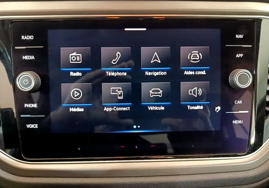 Écran tactile central du tableau de bord du Volkswagen T-Roc 2021 affichant les options multimédia et aides à la conduite.