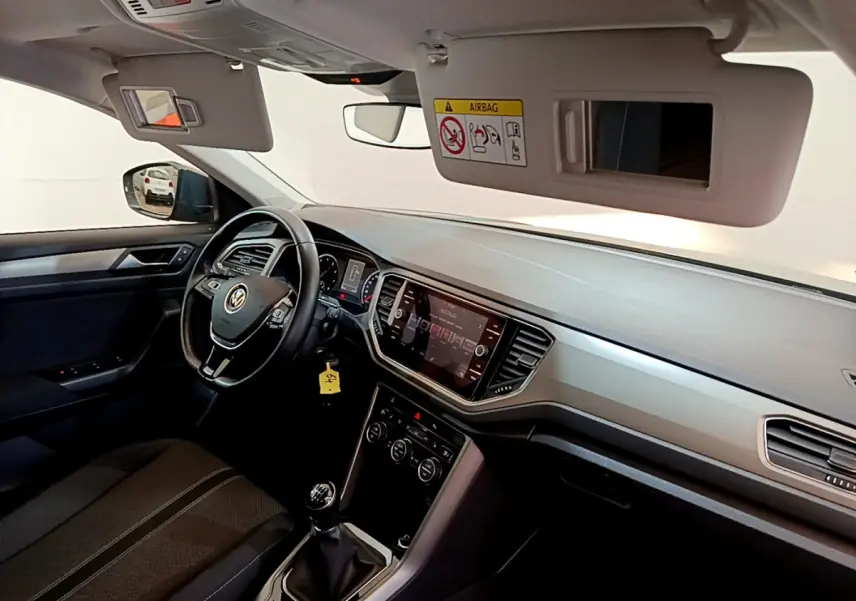 Intérieur du Volkswagen T-Roc 1.0 TSI 110 Lounge 2021 vu côté conducteur, tableau de bord moderne et volant cuir noir.