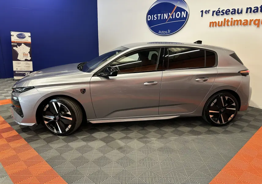 Peugeot 308 gris Artense vue de profil côté gauche, avec jantes noires et détails modernes en showroom.
