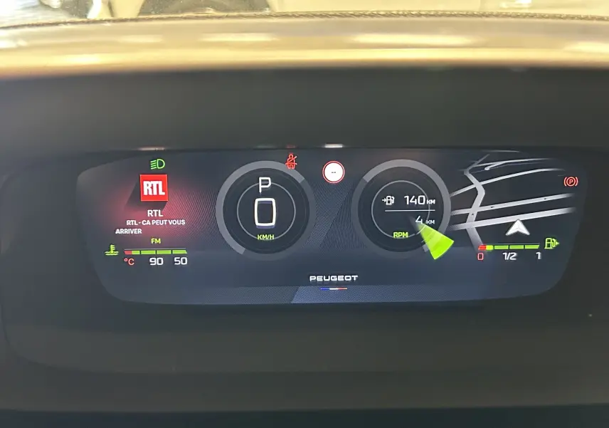 Tableau de bord numérique 10'' 3D de la Peugeot 308 GT gris Artense, affichant vitesse, navigation et radio RTL.