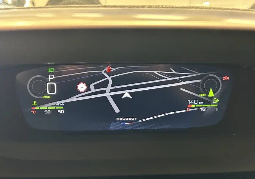 Affichage numérique du tableau de bord Peugeot 308 III Ph.2 GT avec navigation et indicateurs de vitesse et température.