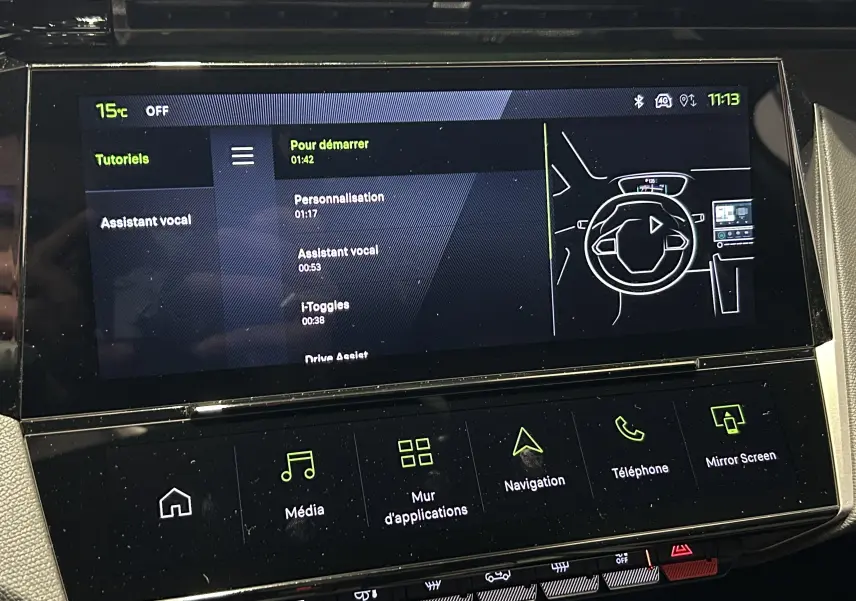 Écran tactile central du Peugeot 308 III Ph.2 GT avec interface de tutoriels et commandes multimédias en vue frontale.