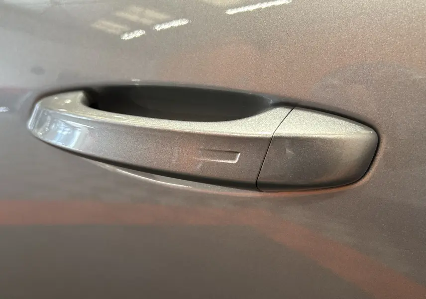 Poignée de porte côté droit gris Artense métallisée d'une Peugeot 308 III Ph.2 GT BlueHDI 130 EAT8, vue en gros plan.