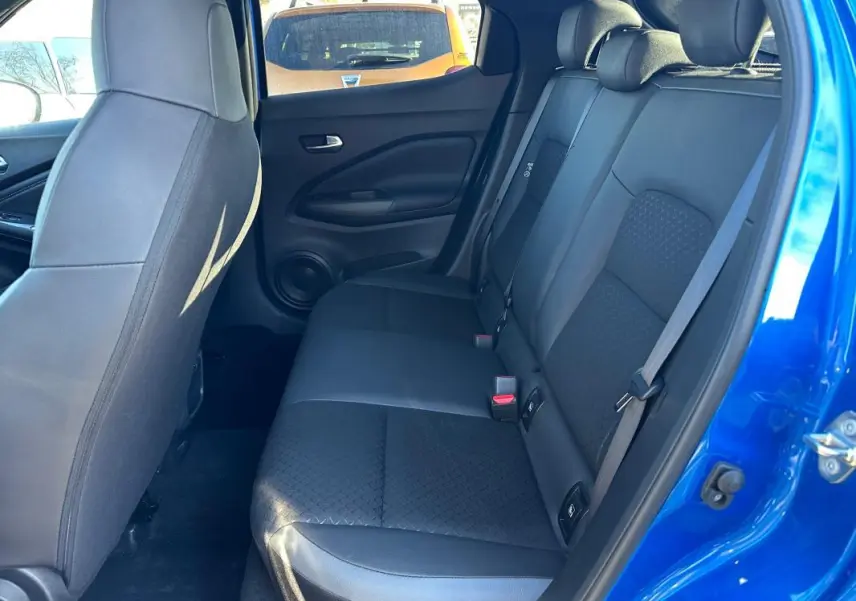 Vue intérieure côté droit des sièges arrière noirs du Nissan Juke 2023.5 bleu clair avec habillage tissu et cuir.