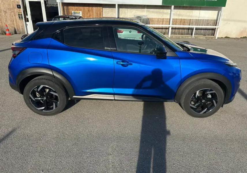 Vue de profil côté gauche d'un Nissan Juke 2024 bleu clair avec jantes alliage noires de 17 pouces.