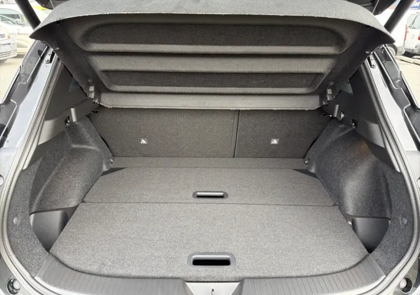 Coffre ouvert vu de l'arrière d'un Nissan Qashqai 1.5 e-Power noir, avec banquette rabattue et espace de chargement plat.