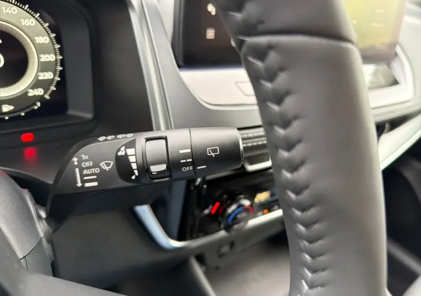 Gros plan sur le commodo d'essuie-glace à gauche du volant cuir noir du Nissan Qashqai 1.5 e-Power 2025.