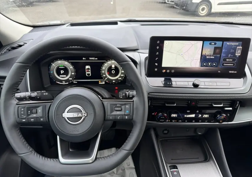 Vue intérieure du tableau de bord du Nissan Qashqai 1.5 e-Power 2025 avec écran tactile et volant multifonctions noir.