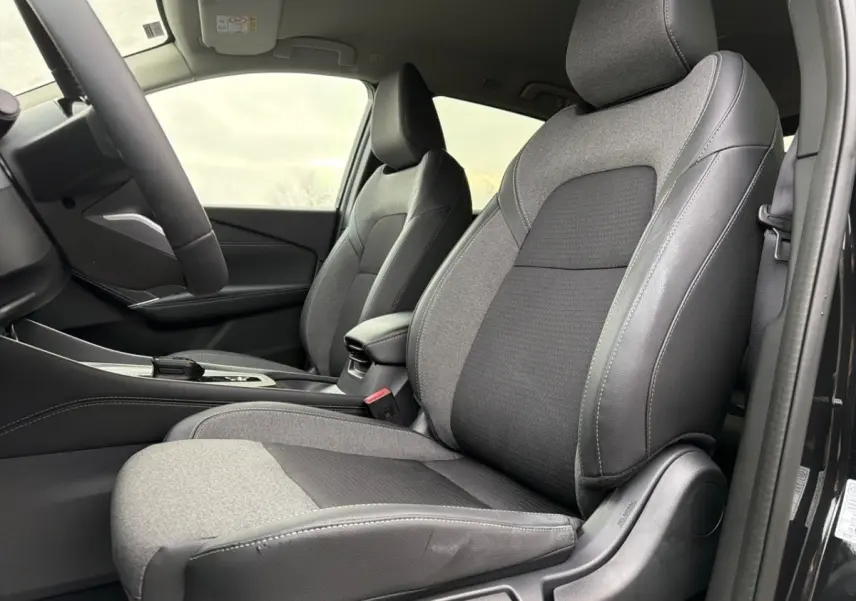 Vue intérieure côté conducteur du Nissan Qashqai noir 2025, mettant en valeur les sièges en tissu et cuir gris et noir.