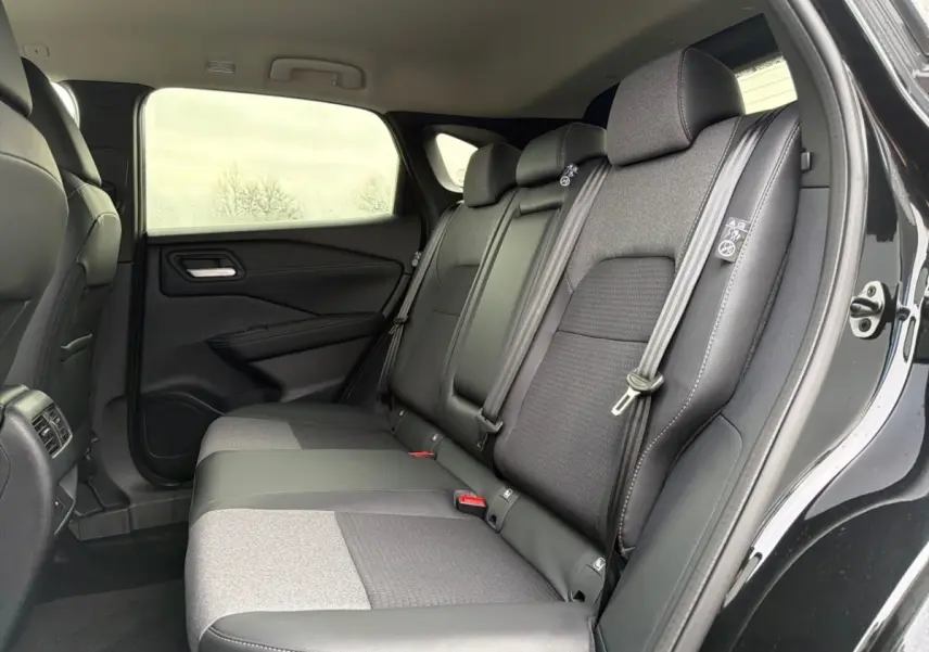 Vue intérieure côté droit sur la banquette arrière noire et grise du Nissan Qashqai 1.5 e-Power 2025 avec portières ouvertes.