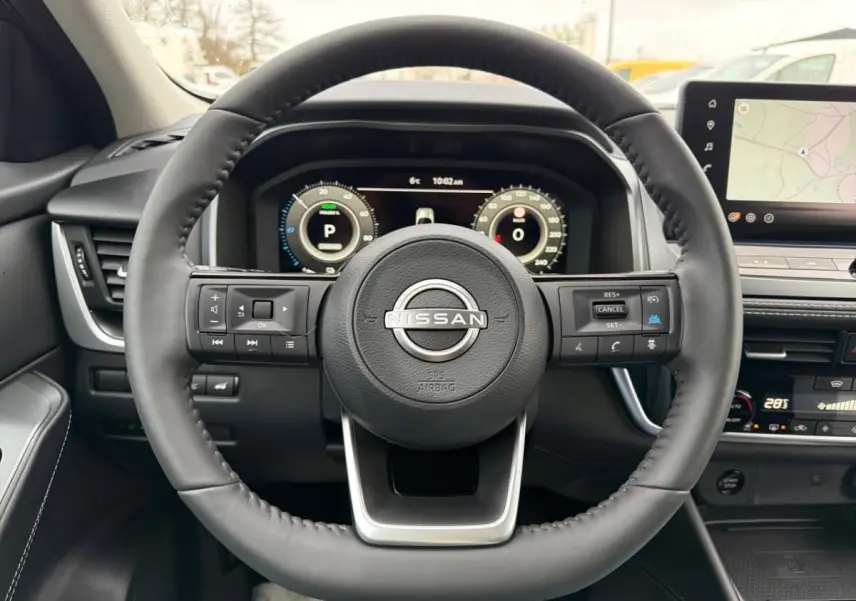 Vue frontale du volant cuir noir du Nissan Qashqai 1.5 e-Power avec tableau de bord numérique et écran tactile GPS.
