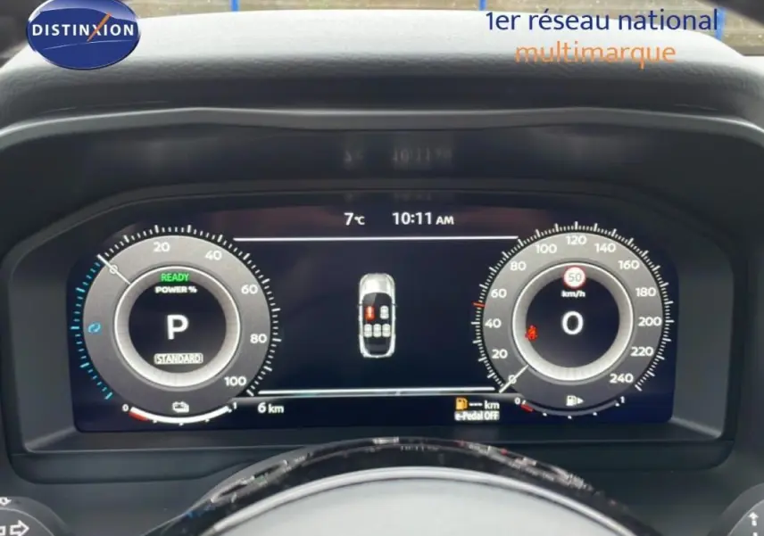 Vue frontale du cockpit numérique du Nissan Qashqai blanc 2025, affichant la vitesse et l'état du véhicule.