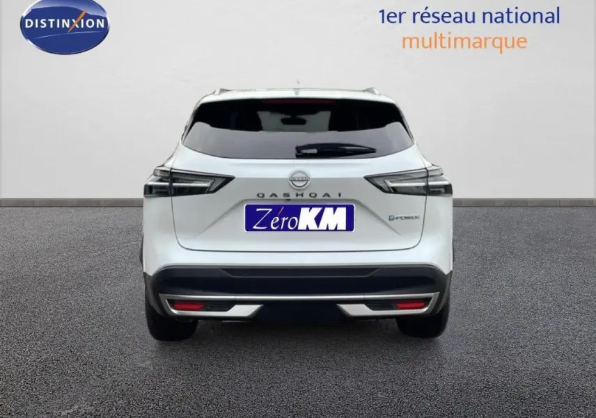 Vue arrière d'un Nissan Qashqai blanc 2025 avec feux LED et badge E-POWER, stationné sur sol gris.
