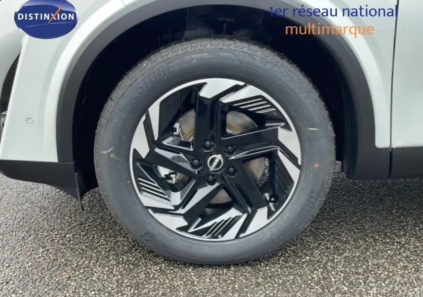 Gros plan sur la jante aluminium noire et argentée du côté gauche du Nissan Qashqai blanc 2025.