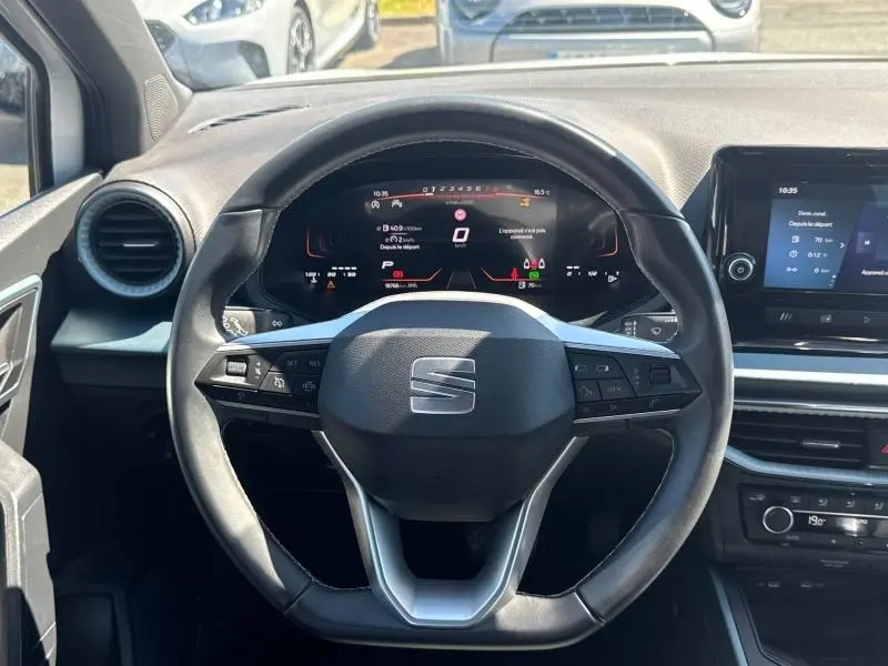 Vue intérieure frontale du volant cuir noir et du tableau de bord digital du SEAT Arona 2025.