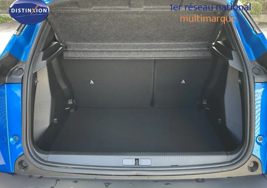 Coffre ouvert d'un Peugeot 2008 bleu Vertigo Metal, montrant l'espace de chargement vide et la trappe arrière.